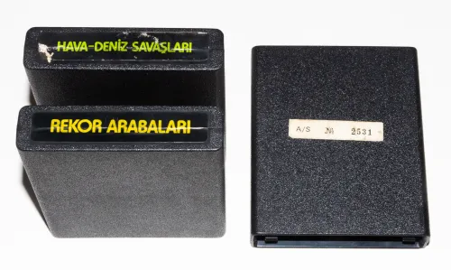 Author photo showing two Turkish-made cartridges in my collection that retained their end labels (Hava-Deniz Savaslari, and Rekor Arabalari), as well as one cartridge (Meteoryar Geliyor) that retained on its back a small sticker with a serial number.